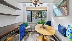 A modern kitchen with a wooden countertop, blue cabinets, a dining table, and a bench with cushions. - Radiant Villa w/ Balcony, Deck & Amenities (Hilton Head Island)