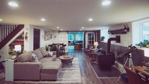 A spacious living room with a sectional sofa, a coffee table, and a telescope. - RIVER FRONT Pickleball & Bball Patio-Pets-2 houses (Free Soil)