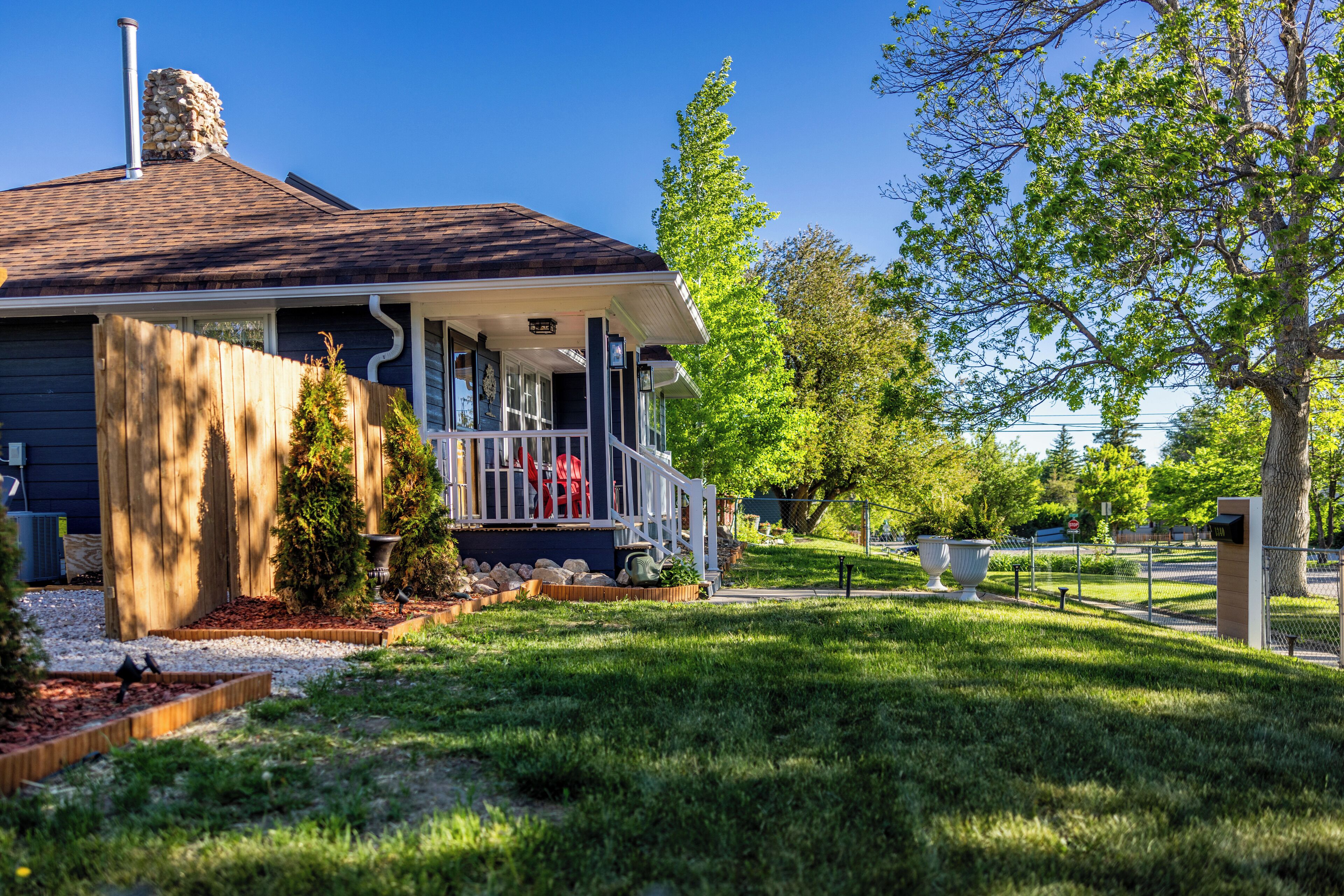 A house with a porch, a chimney, and a well-maintained lawn.