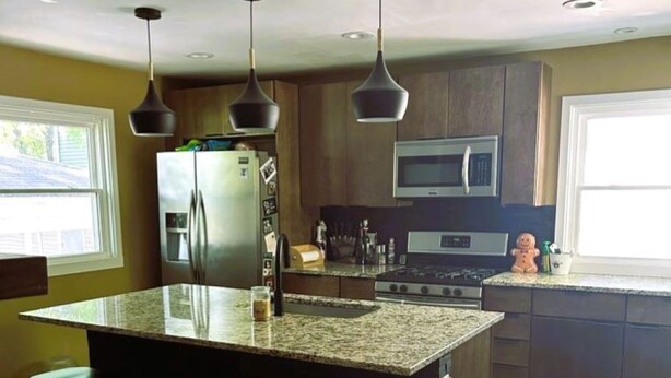 A kitchen with granite countertops, stainless steel appliances, and pendant lighting. - House for Rent- EAA  (Oshkosh)