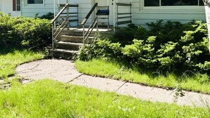 A single-story house with a front porch, a small staircase, and a visible front door. - House for Rent- EAA  (Oshkosh)