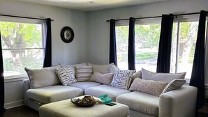 A living room with a sectional sofa, a coffee table, and a patterned rug. - House for Rent- EAA  (Oshkosh)