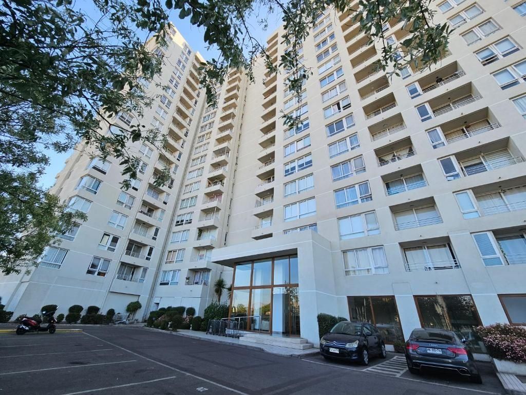 A multi-story residential building with a parking lot in front.