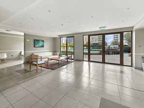 A spacious room with a large sliding glass door leading to an outdoor area, a sofa, a coffee table, and a rug.