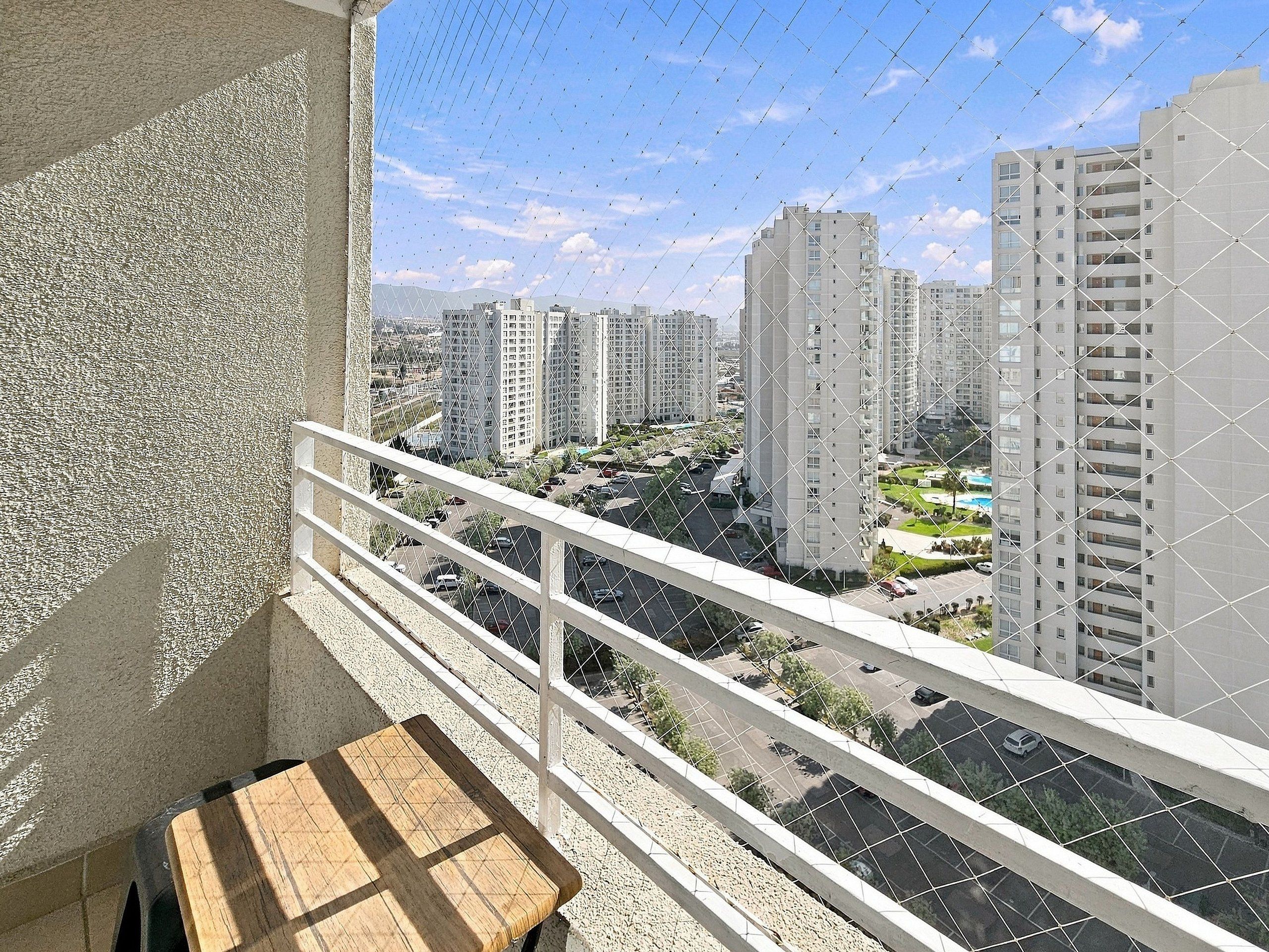 Un balcon avec vue sur des immeubles de grande hauteur et un espace de stationnement.