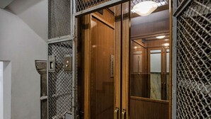 A wooden door with metal mesh and a light fixture above it. - Casa Alma by Wonderful Italy (Genoa)