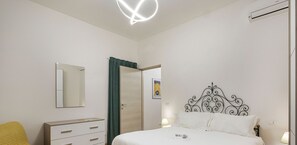 A bedroom with a bed, a bedside table, a mirror, a wardrobe, and a door. - Casa Alma by Wonderful Italy (Genoa)