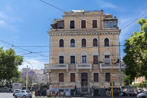 Un immeuble à plusieurs étages, de style architectural classique, caractérisé par des fenêtres en arc de cercle et des balcons.