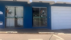 A building with a blue facade, numbered 270, featuring two glass doors with 'HP' signage, a white garage door, and a balcony with white railings.