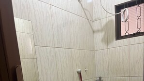 A small bathroom with a toilet, sink, and a shower area.
