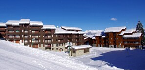 A snow-covered building with multiple balconies and a ski slope in the foreground. - 1st floor, view ski slopes, balcony, tv, 25m², Valmorel (Valmorel)