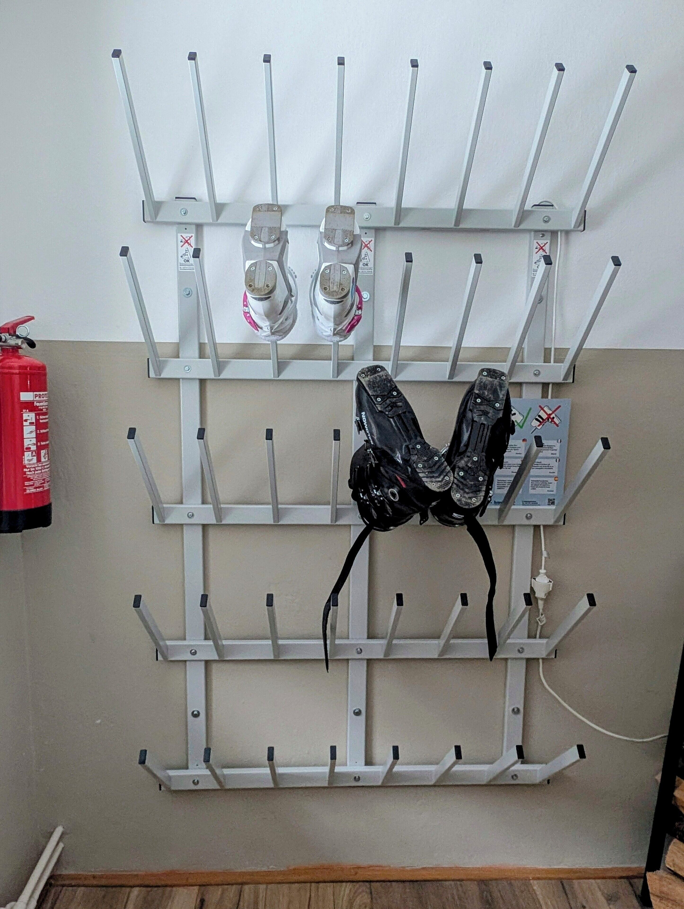 A wall-mounted rack with multiple hooks, a fire extinguisher, and a power outlet.