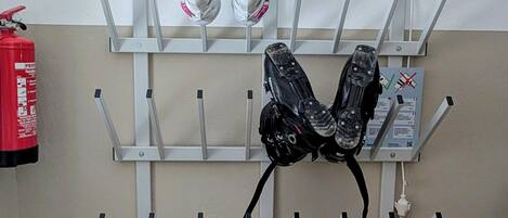 A wall-mounted rack with multiple hooks, a fire extinguisher, and a power outlet.