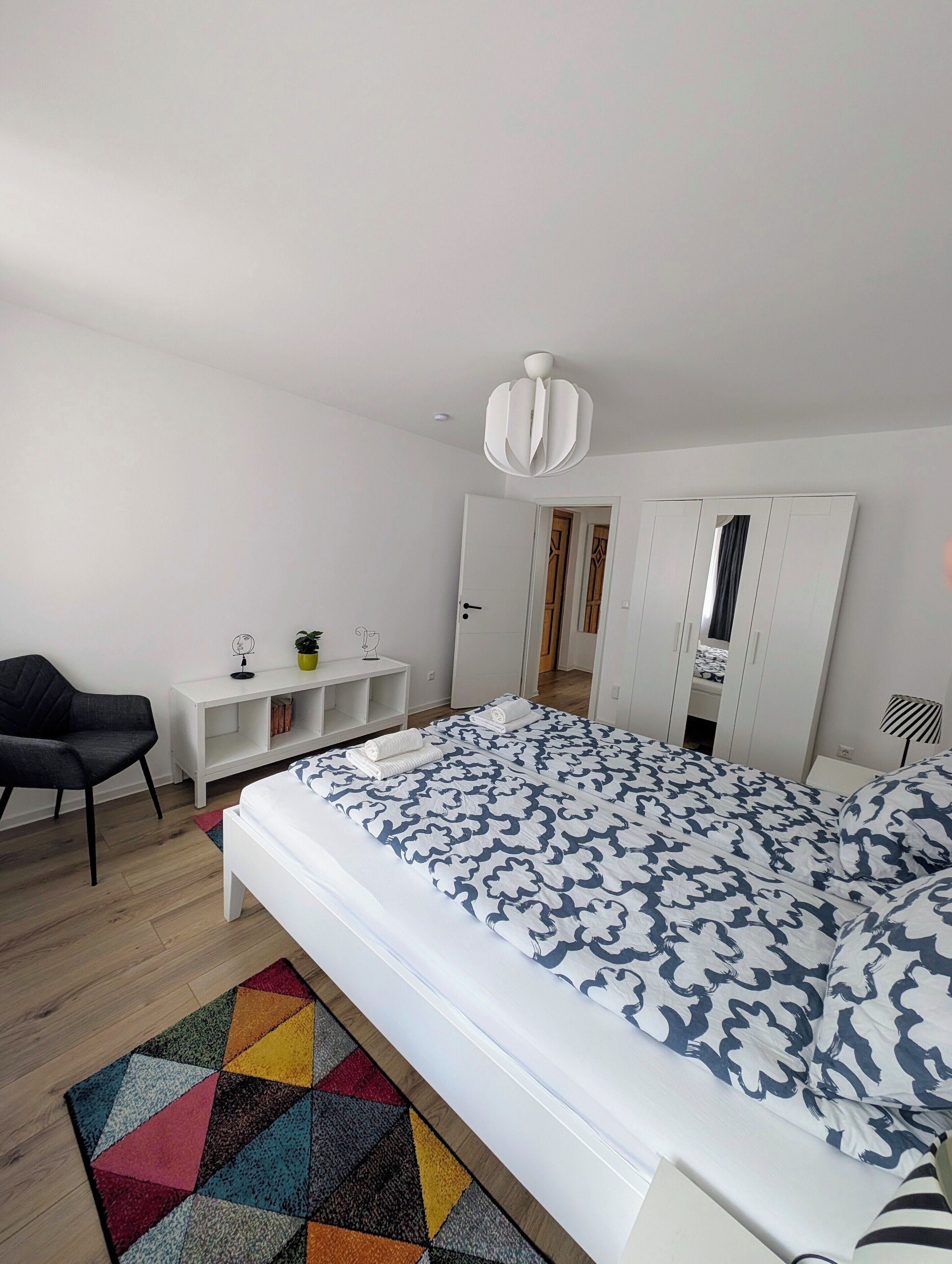 Ein Schlafzimmer mit einem Bett, einem Schreibtisch, einem Stuhl und einem Kleiderschrank.
