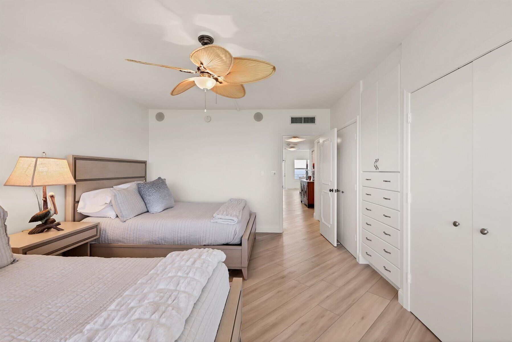 Un dormitorio con cama, mesita de noche, lámpara y ventilador de techo.