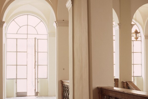 A corridor with arched doorways and a wooden bench. - Penthouse to LIVE: in PALACE with terrace (Fermo)