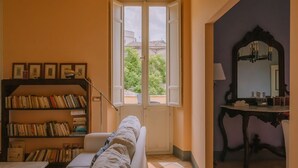 A room with a large window, a bookshelf, a sofa, and a mirror. - Penthouse to LIVE: in PALACE with terrace (Fermo)