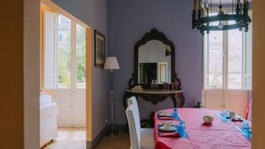A dining area with a red tablecloth, white chairs, and a large mirror above the table. - Penthouse to LIVE: in PALACE with terrace (Fermo)