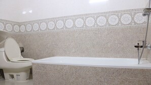 Un baño con inodoro, bañera y ducha.