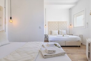 A modern bedroom with a large bed, a smaller bed, and a bedside table. - CITY STAYS ROSSIO II APARTMENTS (Lisbon)