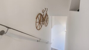 Una escalera con barandilla metálica y un adorno de bicicleta en la pared.