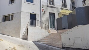 Un edificio de varios pisos con una escalera que conduce a la entrada.