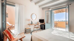 A bedroom with a bed, a desk with a computer, a chair, a small table, and a window with a view. - Planeta Country House & Beach Club (Menfi)