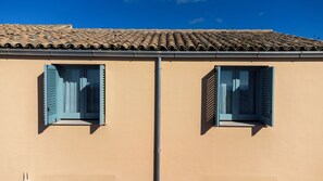 A building with two windows, a tiled roof, and a beige wall. - Planeta Country House & Beach Club (Menfi)