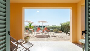 An outdoor patio with chairs, tables, and umbrellas. - Planeta Country House & Beach Club (Menfi)