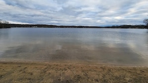 Un lago amplio y tranquilo bajo un cielo nublado.