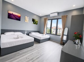 Ein modernes Hotelzimmer mit zwei Betten, einem großen Fenster mit Blick auf die Stadt und Kunstwerken an den Wänden.