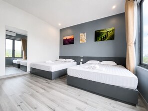 Una habitación de hotel moderna con dos camas, un ventanal grande y una obra de arte en la pared.