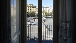 A view from a room through a door with a balcony, overlooking a street with buildings and parked cars. - Ambasciata Sorrento Relais (Sorrento)