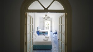 A hotel room with a bed, a small table, and a chandelier. - Ambasciata Sorrento Relais (Sorrento)