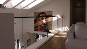 A modern living room with a skylight, a large painting, and a white sofa. - Cape white villa - Family & Friends suite (Cape Town)