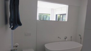 Un baño con bañera, inodoro y ventana.
