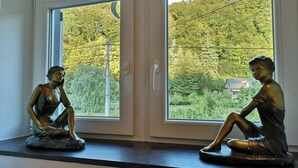 Dos estatuas de bronce de mujeres sentadas en un alféizar.
