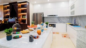 A modern kitchen with white cabinets, a marble countertop, and a built-in oven. - Pearl Villas Phuong Bai Chay Ha Long   (Bai Chay)
