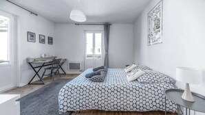 Une chambre à coucher moderne avec un lit, un bureau et une chaise.