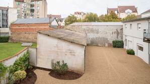 A residential area with a small garden, a brick structure, and surrounding buildings. - Quiet and cosy apartment, free parking (Vichy)