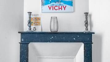 A white wall with a framed poster of a building and the word "VICHY" below it.