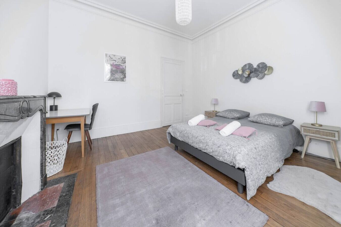 Une chambre à coucher avec un lit, des tables de chevet, un bureau et une chaise.