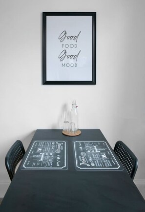 Un cartel enmarcado con el texto 'Good FOOD Good MOOD' sobre una mesa con un menú en pizarra.