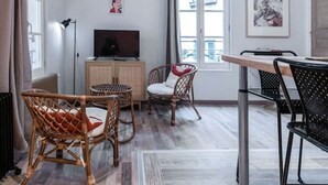 Una sala de estar moderna con comedor, televisor y vistas de la ciudad.