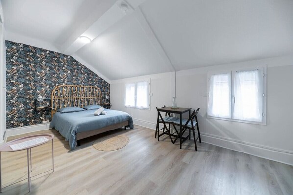 Un dormitorio con una cama, un escritorio y una silla.