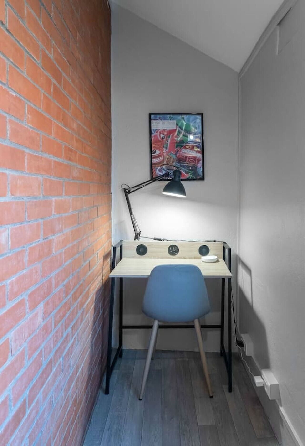 Een werkplek in de hoek met een bureau, stoel en bureaulamp.