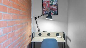 Een werkplek in de hoek met een bureau, stoel en bureaulamp.