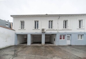 A two-story building with a flat roof, multiple windows, and a central entrance. - Appartement design en centre ville (Vichy)