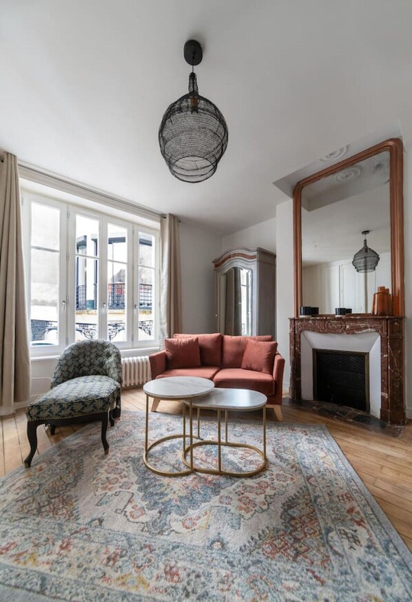 Un salon comprenant un canapé, un fauteuil, une table basse et une cheminée.