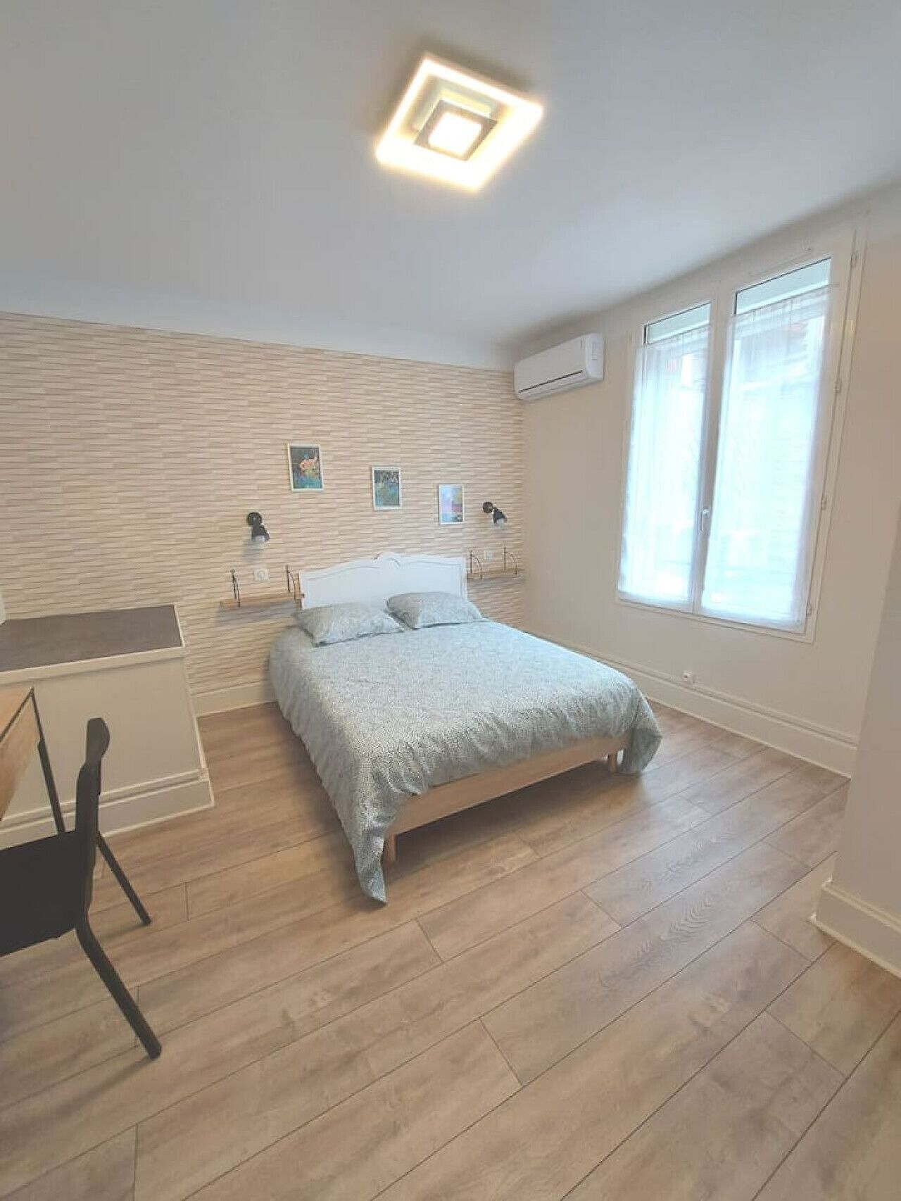 Ein Schlafzimmer mit Bett, Schreibtisch und Fenster.